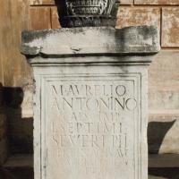 Statue Base with Column Capital - Exterior: View of an Inscribed Statue Base with a weathered Column Capital on top of it