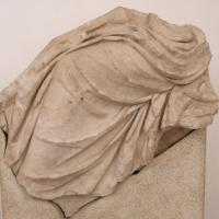 Marble Relief Fragment  - View of a marble fragment of a seated figure