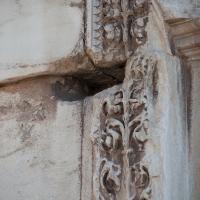 Arch of Titus - Detail: View of carved ornamentation next to a relief panel depicting the spoils from the sack of Jerusalem on the north pier of the Arch of Titus
